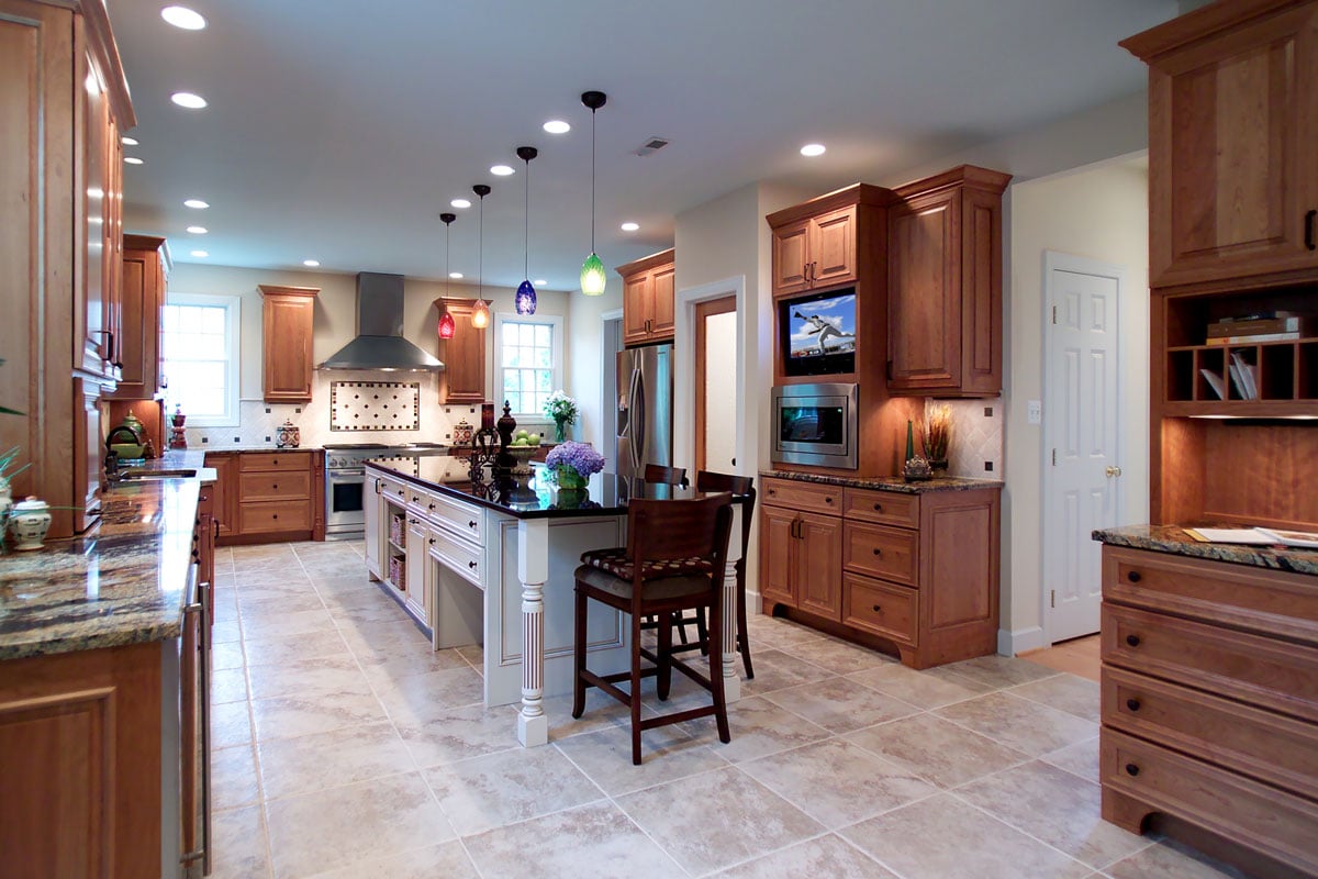 Open kitchen floor plan with hanging lights, high-boy chairs and kitchen island seating.