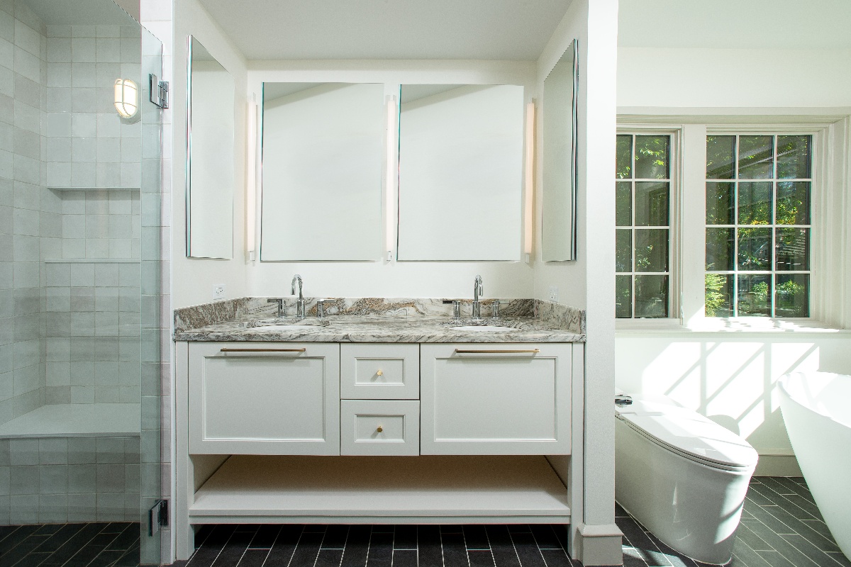 Bathroom vanity with frameless mirrors with hard white lighting behind them