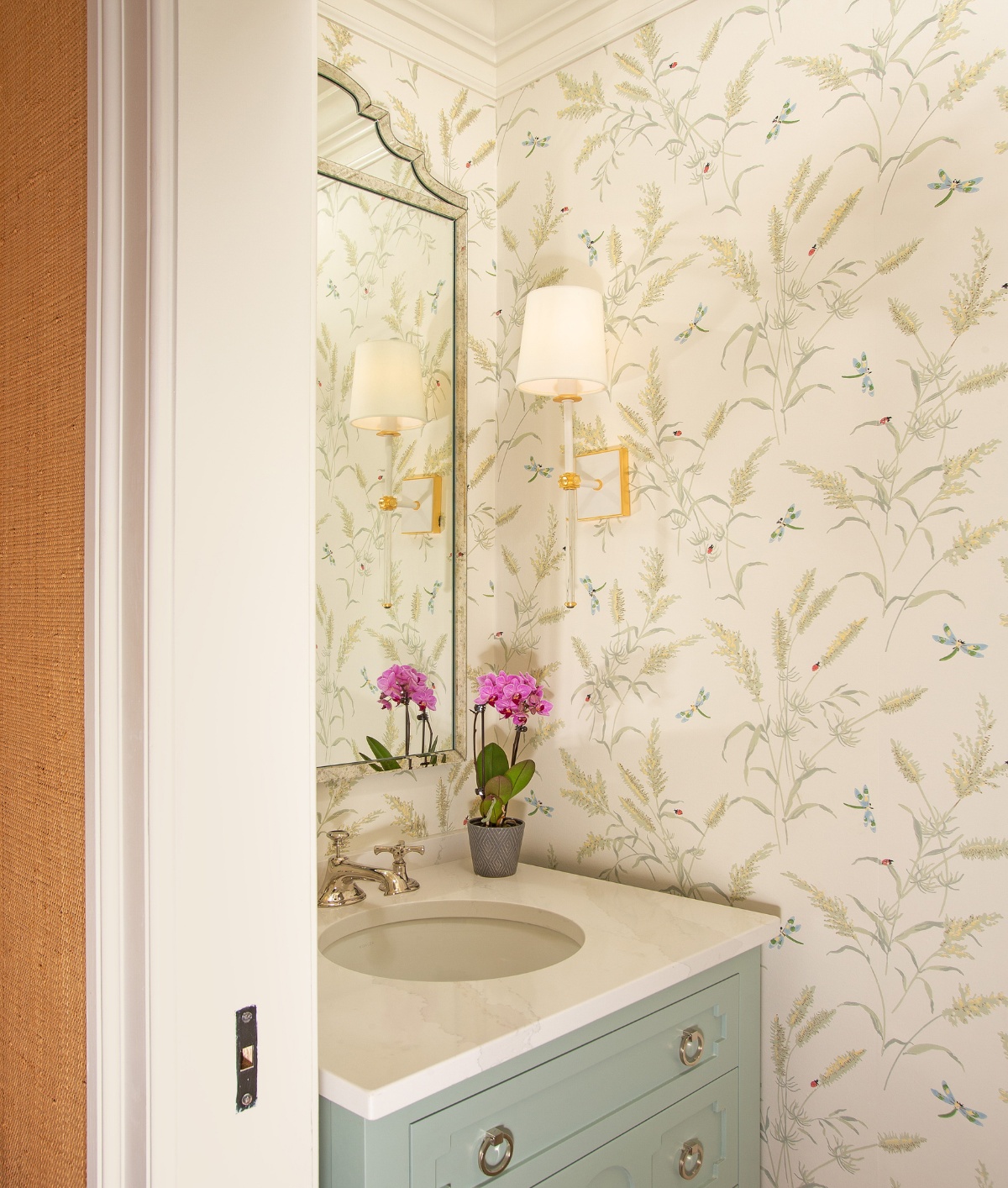 Pure powder room with single vanity and a floral wallpaper to compliment the pastel cabinet